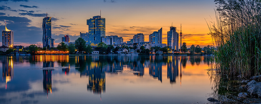 Blick von der Donau aus auf Wien am Abend