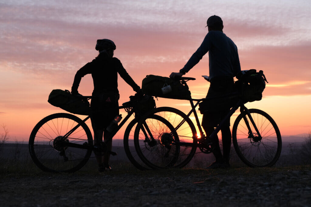 Zwei Radfahrer bei Sonnenuntergang.